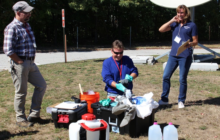 Group of instructors with chemicals and materials on the ground